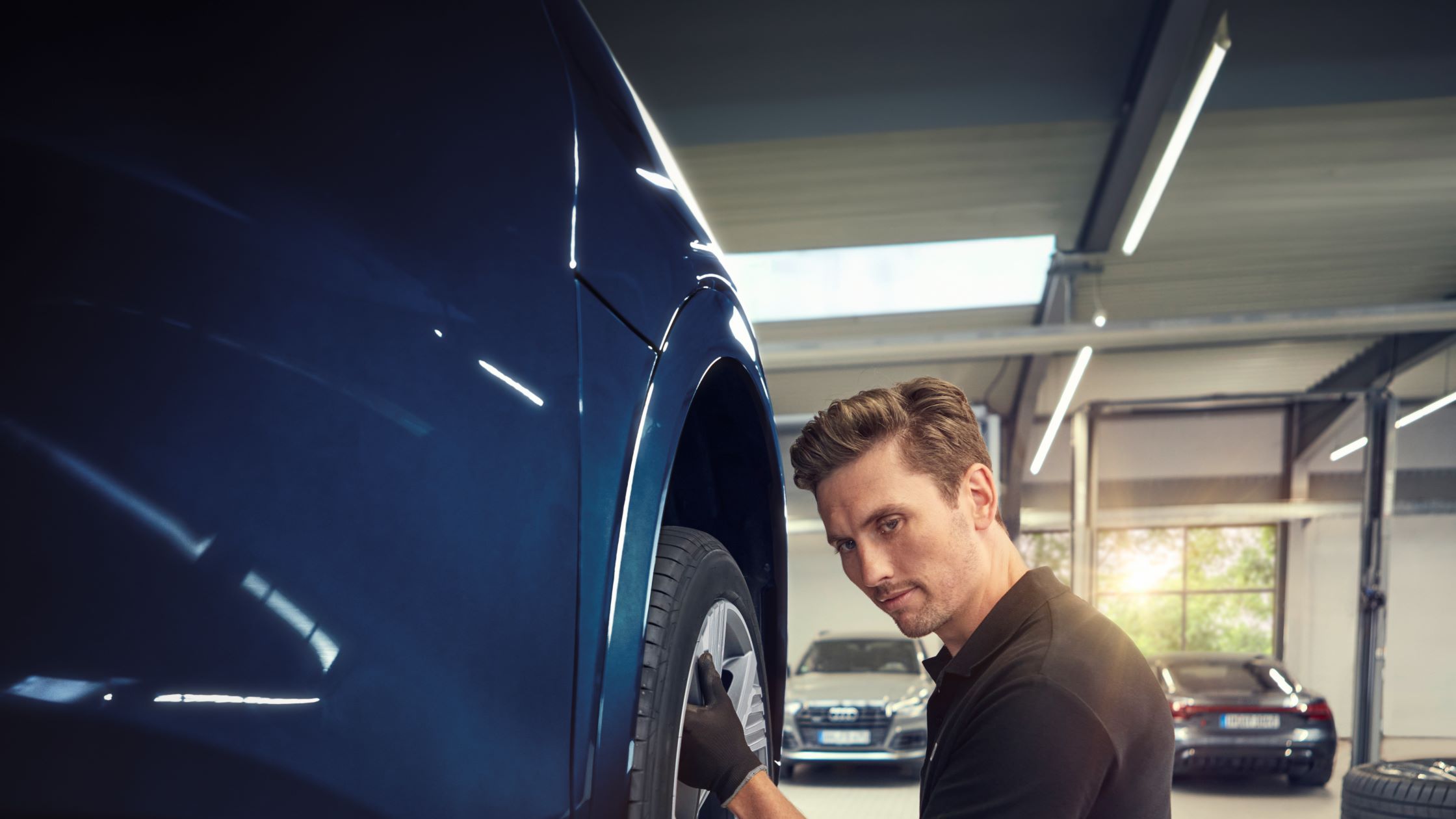 Ein Audi Mechaniker beim Räderwechsel