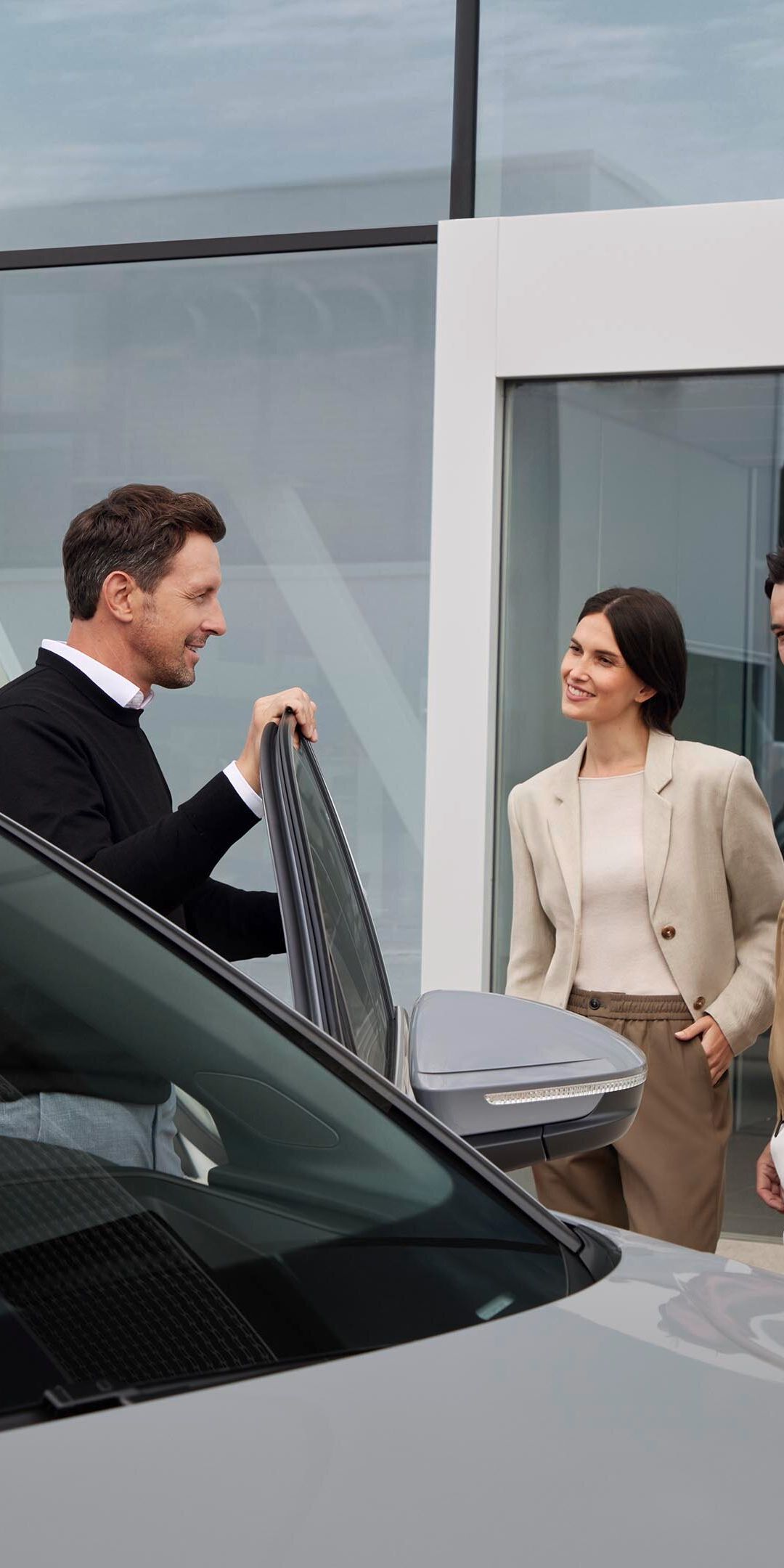 Ein Audi Service Mitarbeiter vor einem Audi im Kundengespräch.