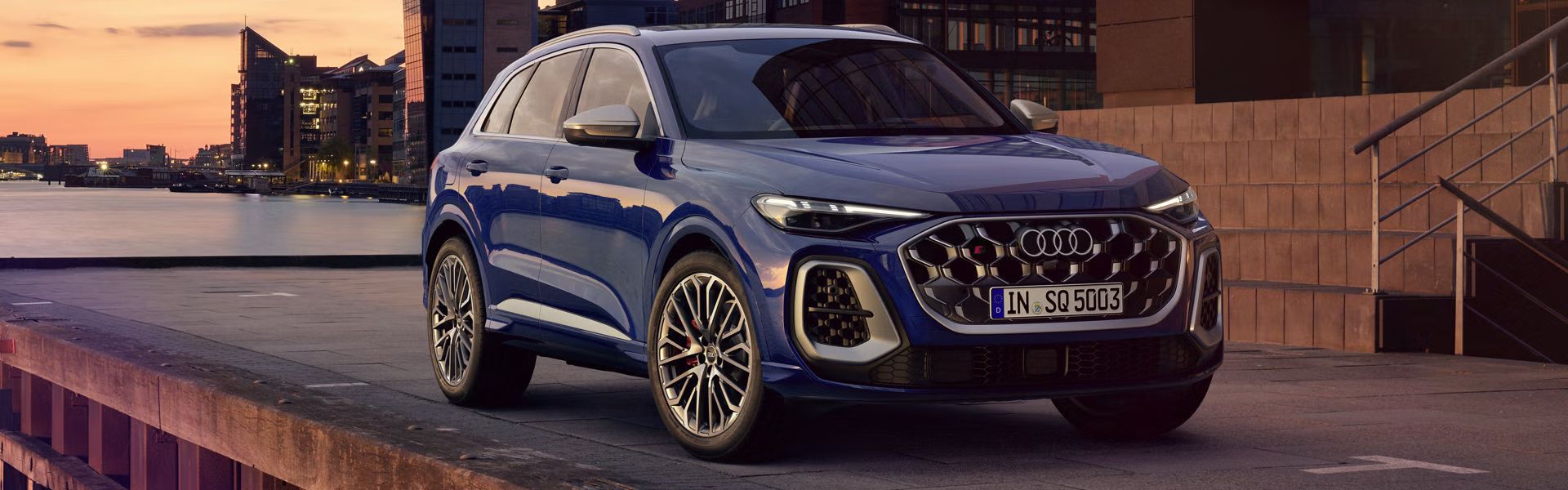 Der SQ5 SUV steht vor der Skyline einer Küstenstadt. 