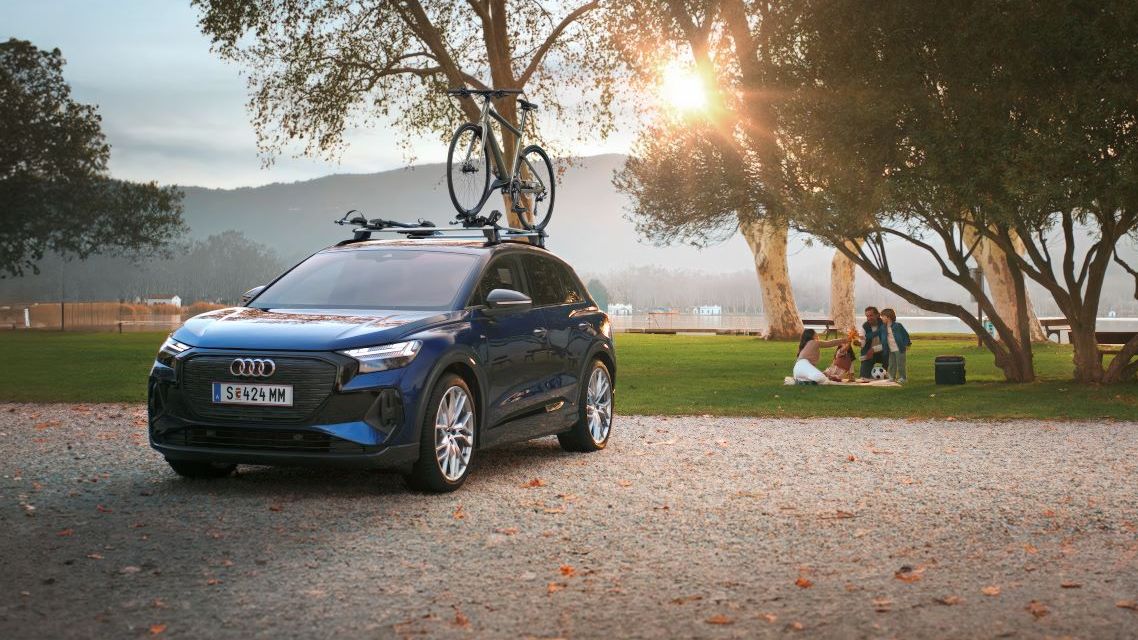 Ein blauer Audi mit Fahrradträger und Fahrrad auf dem Dach.