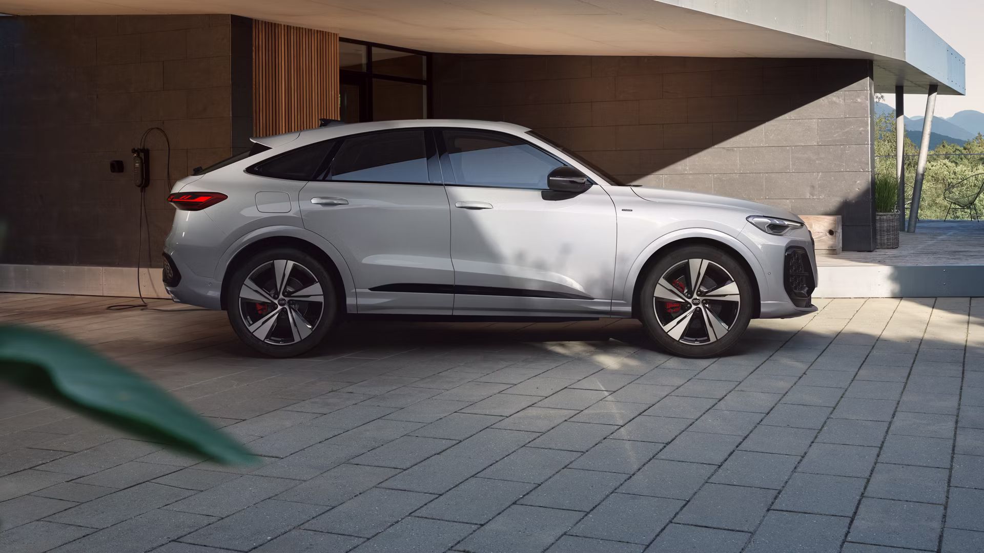 Audi Q5 Sportback e-hybrid Seitenansicht vor einem Haus