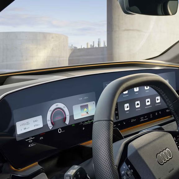 Das Cockpit und Fahrerdisplay aus der Perspektive des Fahrerfensters. Unter der Windschutzscheibe ist das Interaktionslicht in Sonnengelb zu erkennen.