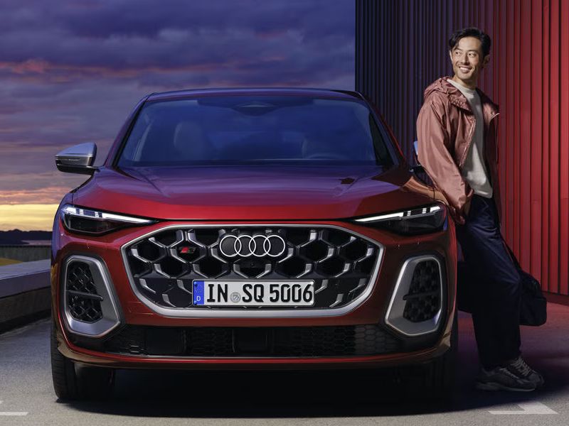 Frontansicht eines roten Audi SQ5 Sportback, an dem ein Mann lehnt