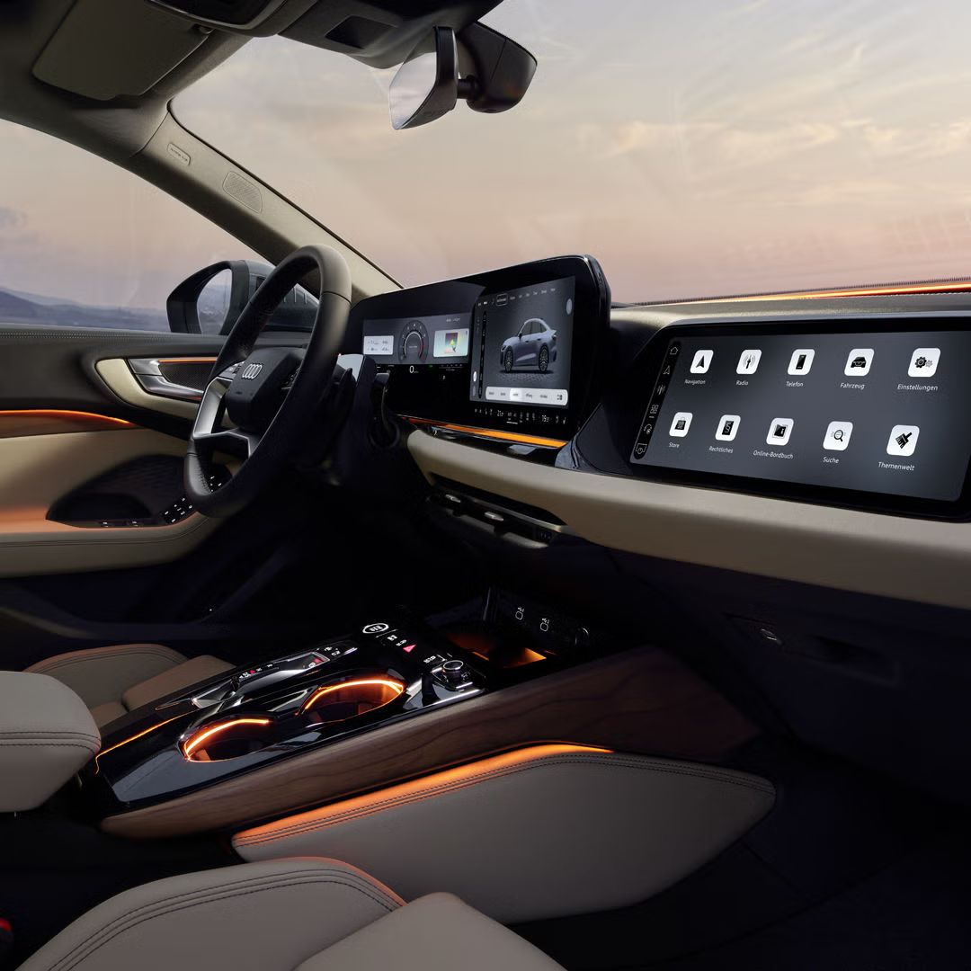 Blick in das Cockpit der A5 Limousine von der Beifahrerseite. Der Innenraum erscheint dabei in orangenem Ambiente Licht.