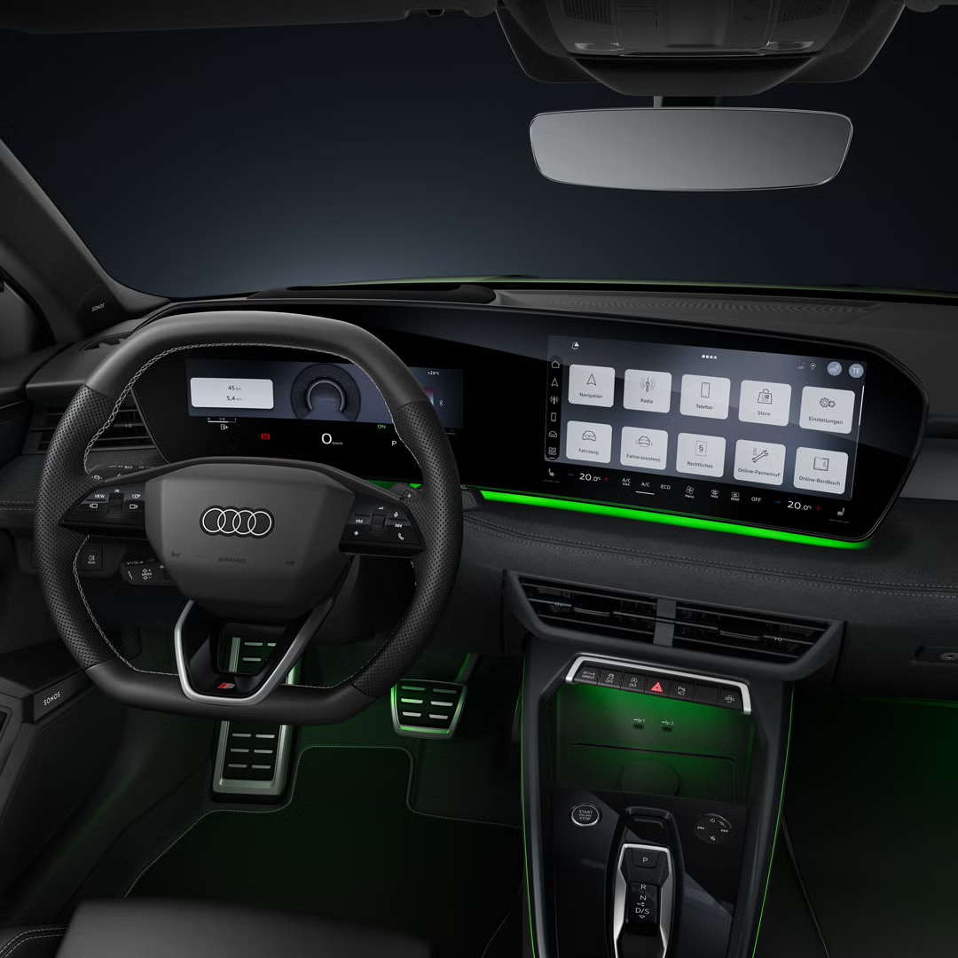 Blick auf das Cockpit mit Fokus auf das Sportlederlenkrad und das geschwungene Panoramadisplay.