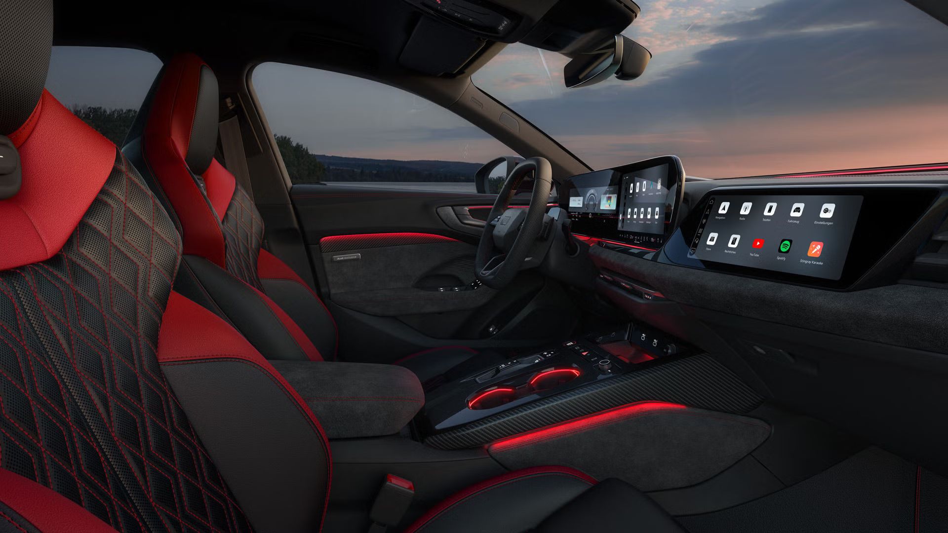 Blick durch das Beifahrerfenster in das Cockpit der A5 Limousine e-hybrid. Die Bezüge sind schwarz mit karmesinroten Akzenten.