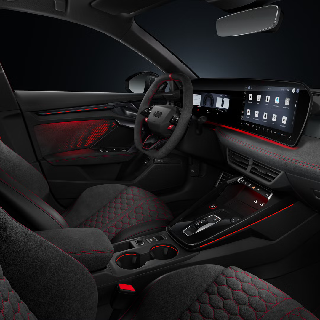 Blick von der Beifahrerseite auf das Cockpit mit Sportkonturlenkrad, Mittelkonsole, digitale Displays und das Ambiente-Licht.