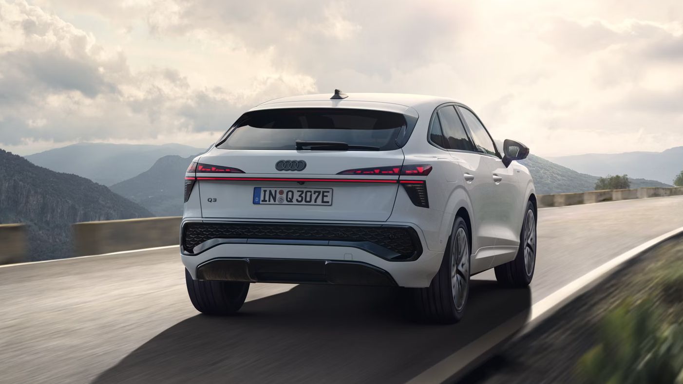 Es ist der Audi Q3 Sportback e-hybrid zu sehen der auf einer Landstraße in den Bergen fährt