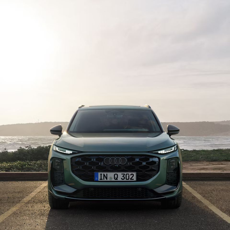 Audi Q3 SUV von vorne auf einem Parkplatz vor einem Gewässer