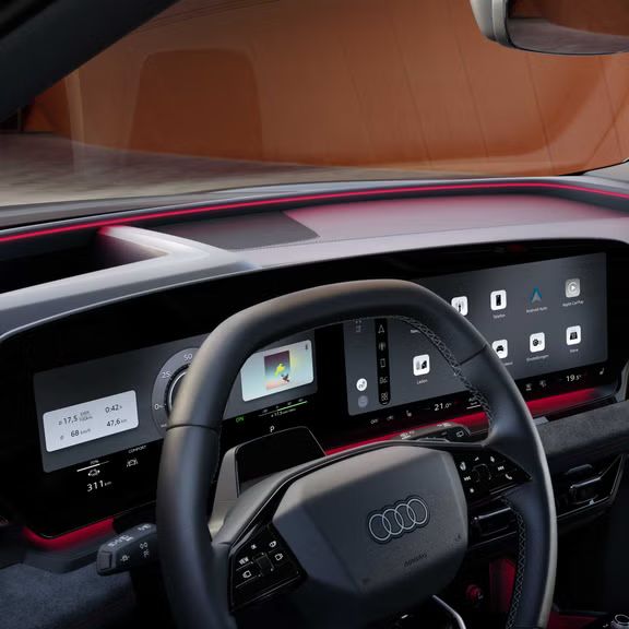 Das Armaturenbrett und die Panorama-Displays aus der Perspektive des Beifahrers. Unter der Windschutzscheibe ist das Interaktionslicht in rot zu erkennen.