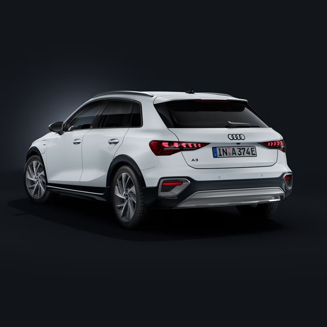 Der Audi A3 Sportback e-hybrid schräg von hinten auf dunklem Hintergrund.