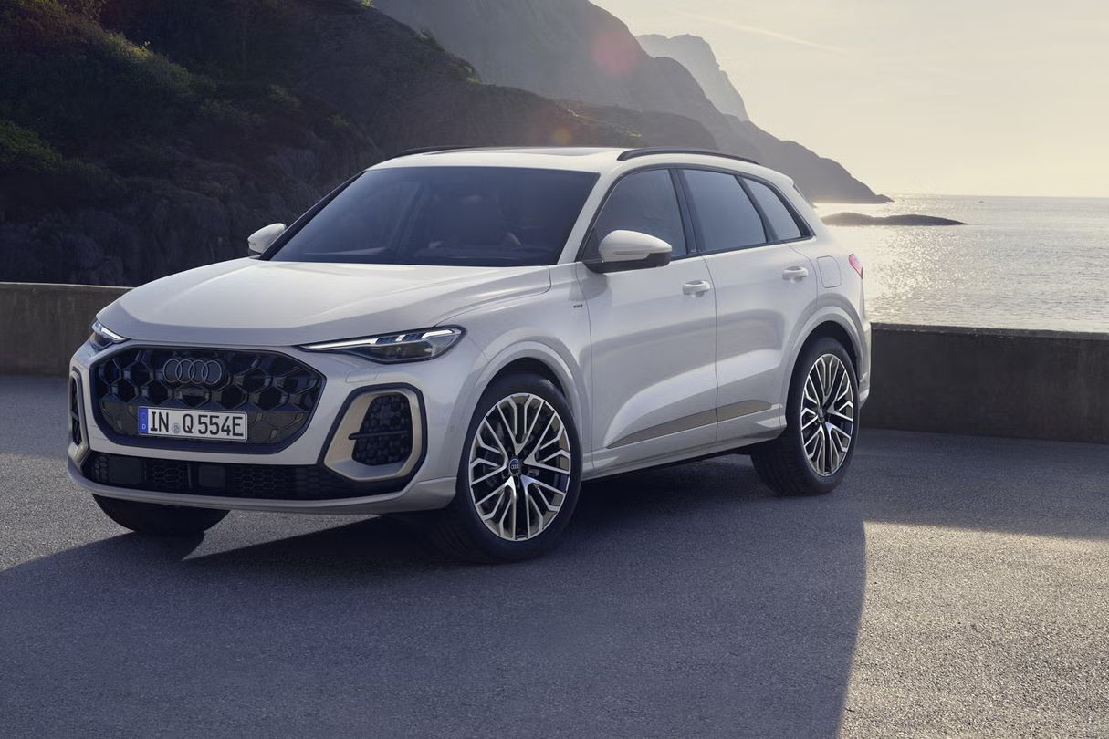 Die graue Edition One mit magnesiumgrauen Akzenten des Q5 SUV e-hybrid steht auf einem Parkplatz vor der Küste.