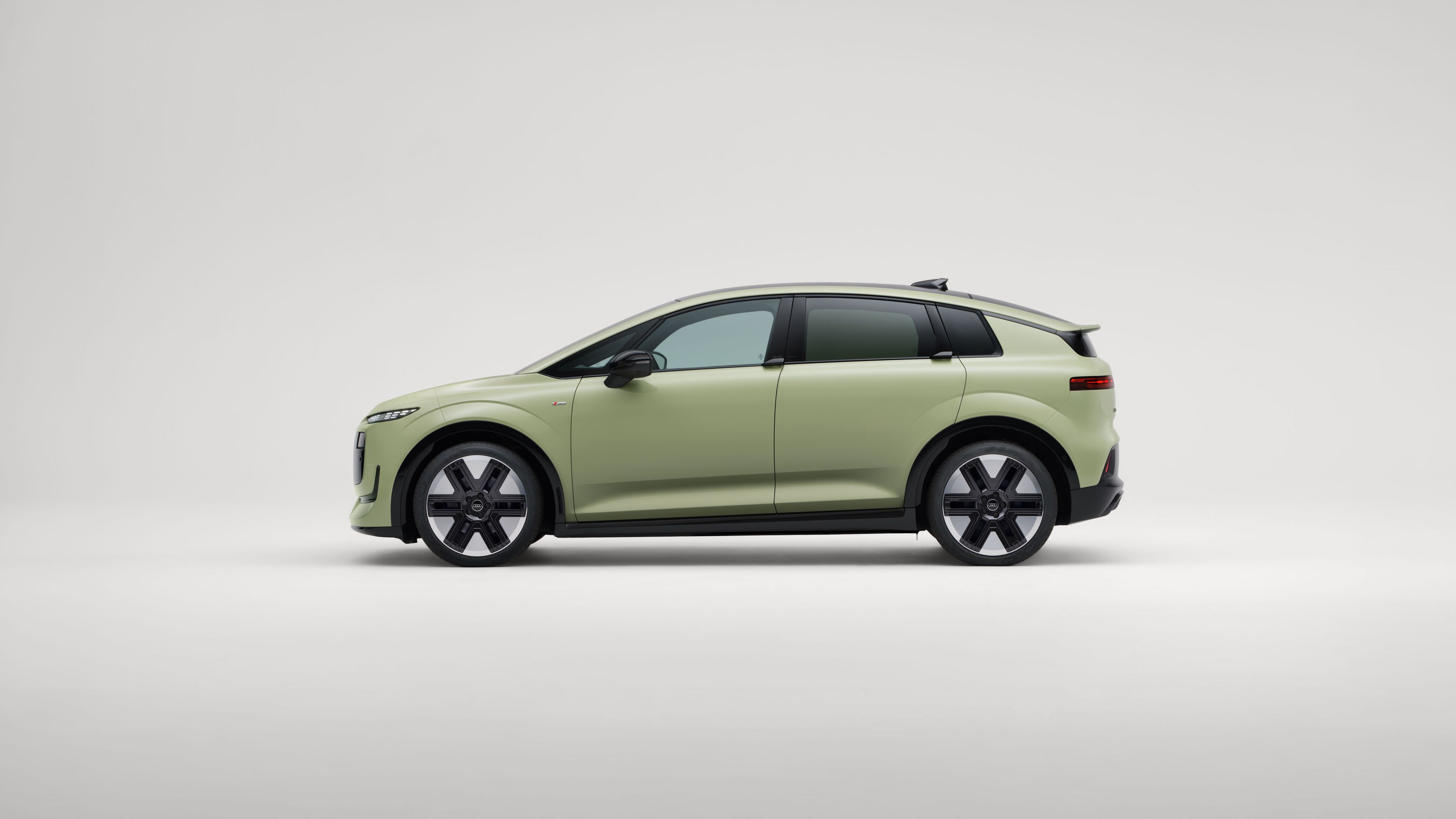 Seitliche Ansicht eines Audi A2 e-tron vor neutral grauem Hintergrund.