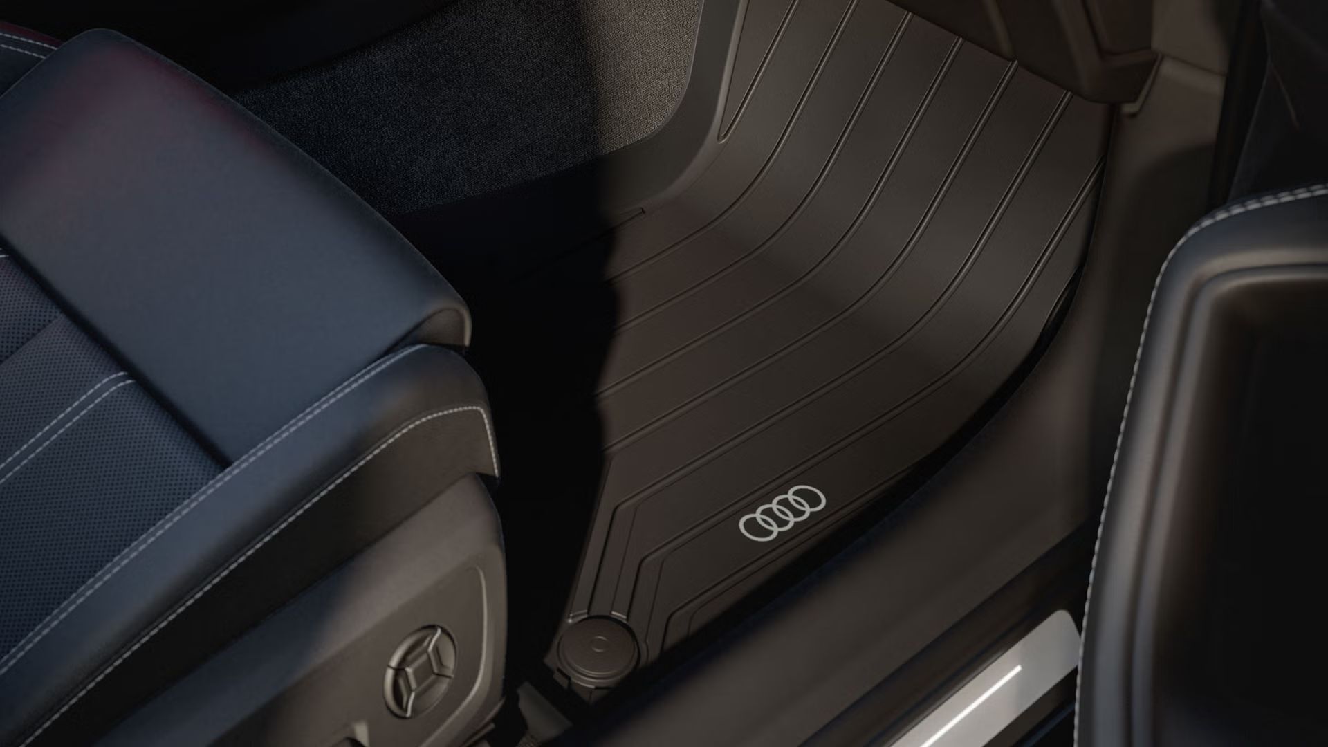 Nahaufnahme der schwarzen Fußmatte mit Audi Logo im Fußraum der A6 Limousine. 
