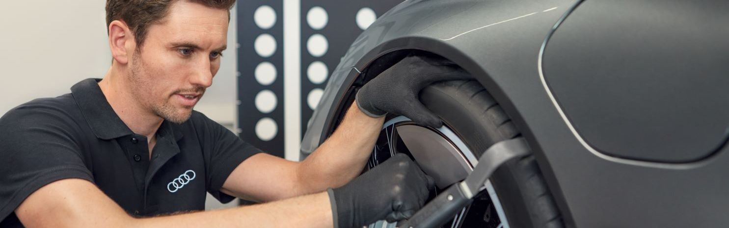 Ein Audi Mechaniker montiert neue Räder an einem Audi