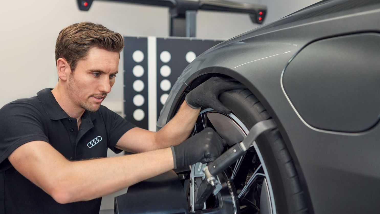 Ein Audi Mechaniker montiert neue Räder an einem Audi