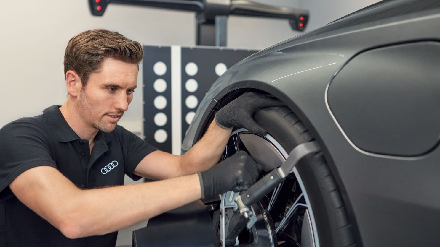 Ein Audi Mechaniker montiert neue Räder an einem Audi