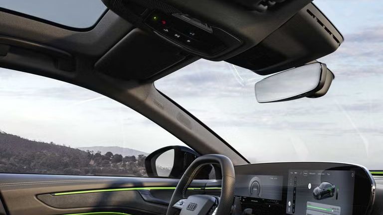 Ansicht des Beifahrers auf das Cockpit, welches in grünem Ambiente-Licht erscheint.