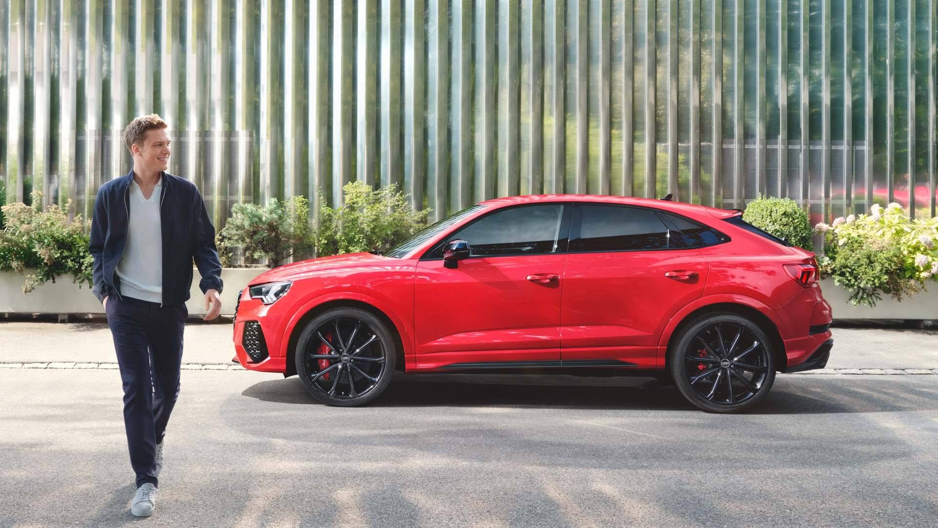 Seitenansicht ded RS Q3 Sportback mit einem Mann im Vordergrund