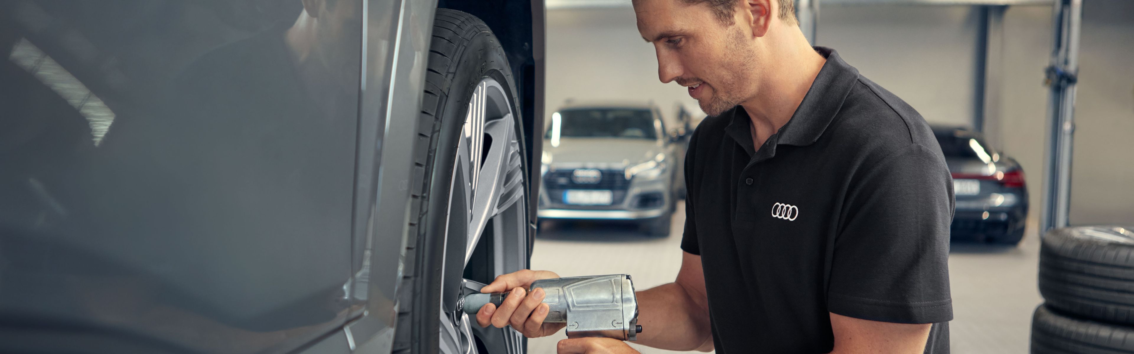 Ein Audi Service Techniker befestigt die Räder an einem Audi Elektroauto