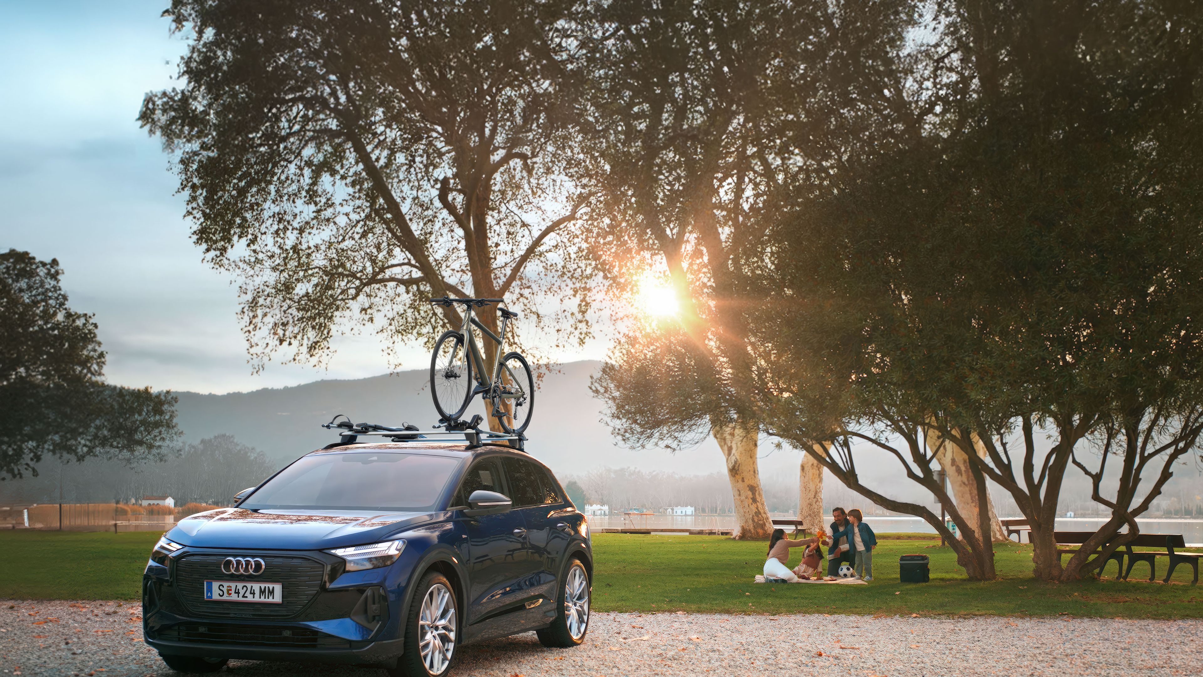 Ein blauer Audi mit Fahrradträger und Fahrrad auf dem Dach.