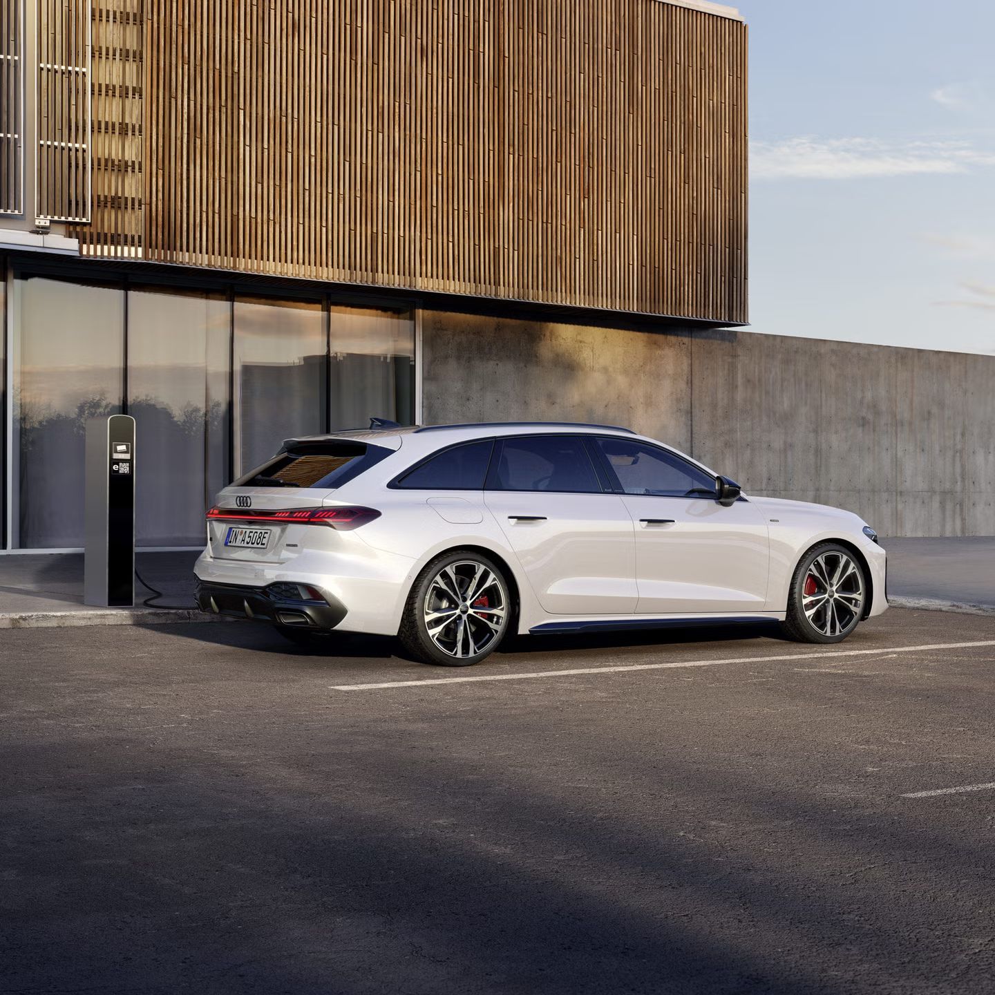 Der A5 Avant e-hybrid steht im schrägen Seitenprofil vor der Fassade eines großen Gebäudes.