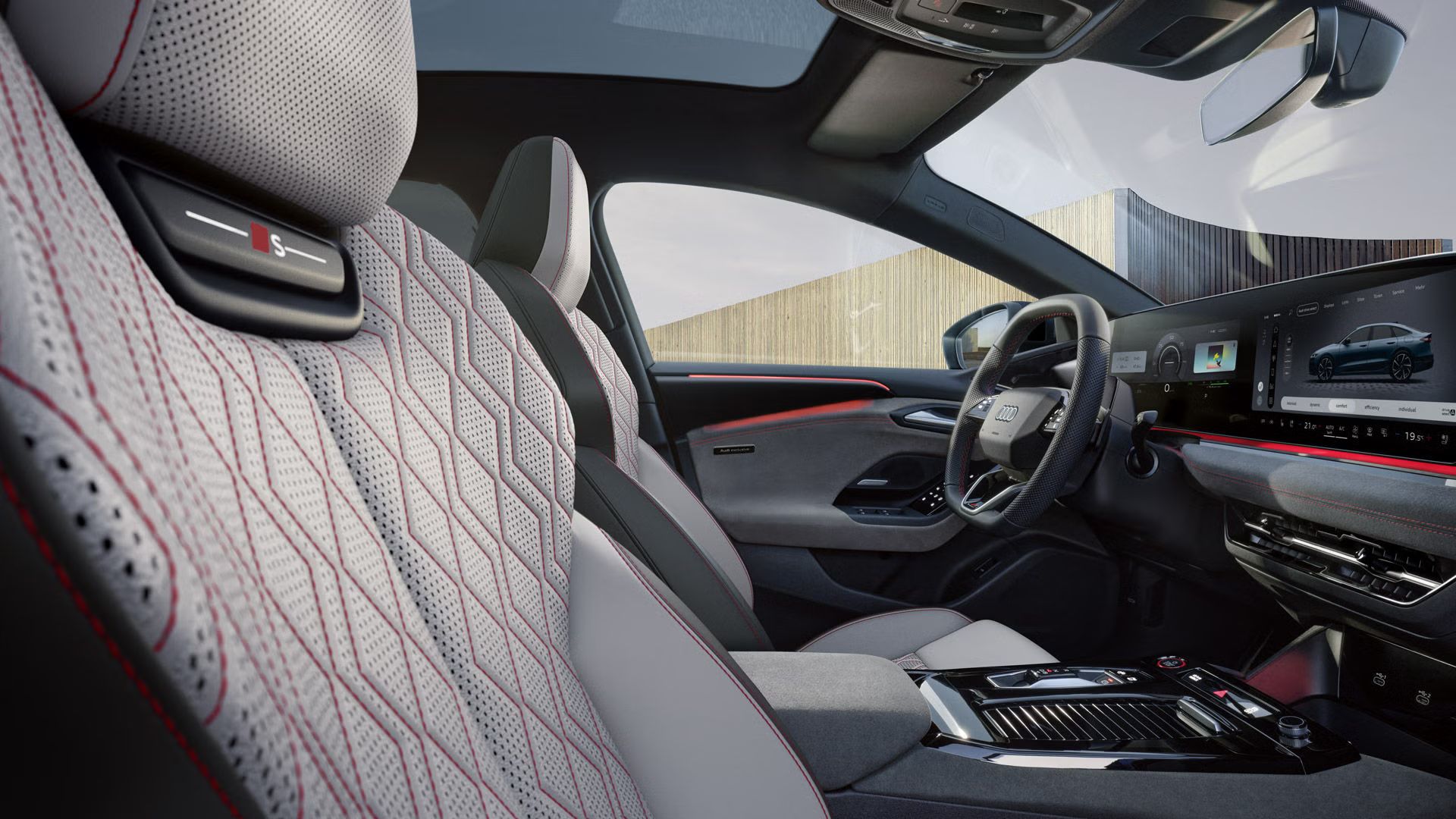 Blick von der Beifahrer-Seite in das Cockpit des S6 Sportback e-tron. Die Sitze haben Bezüge in Leder diamantsilver/jetgrau und Karmesinrote Kontrastnähte. Das Ambientelicht ist ebenfalls rot.