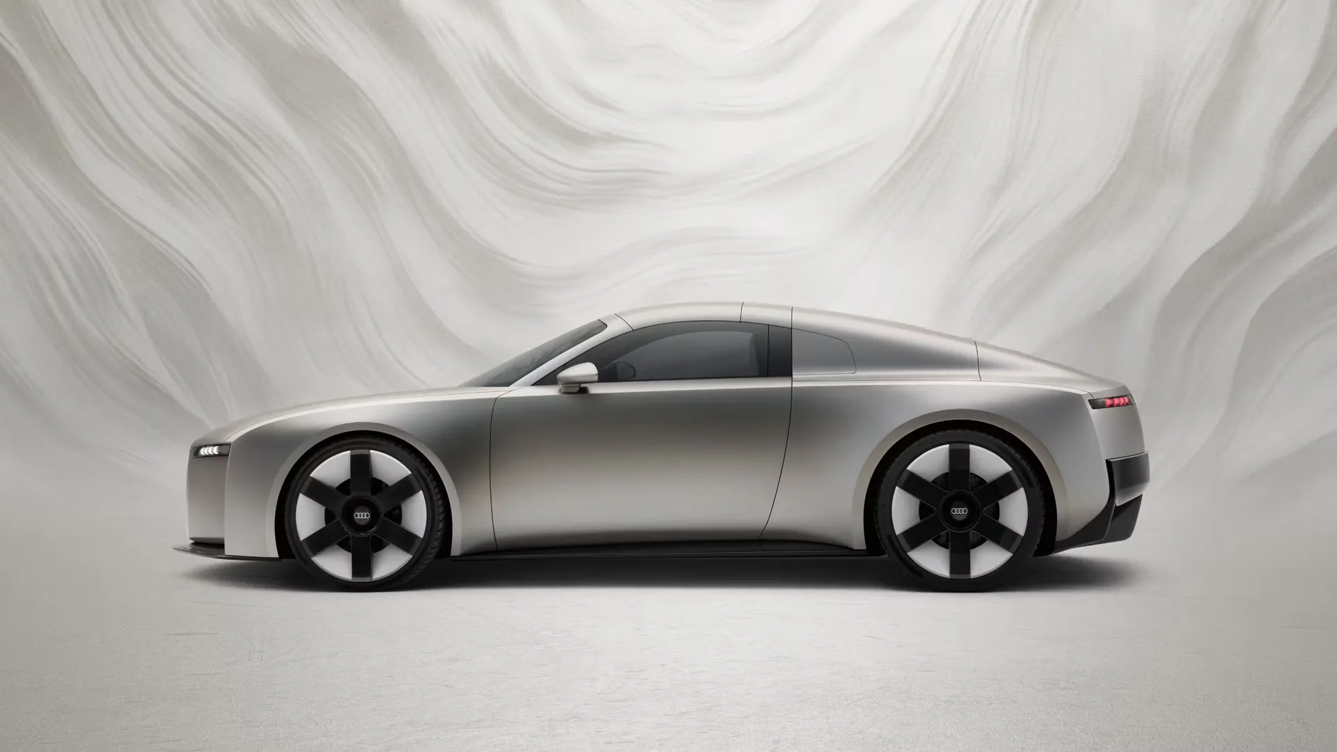 Seitliche Ansicht eines Audi Concept C vor einem graphischen Hintergrund