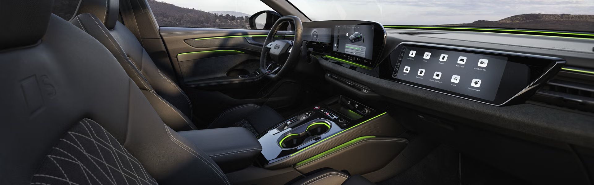 Das Cockpit der A6 Limousine e-hybrid aus Beifahrerperspektive. Der Fokus liegt dabei auf dem Lenkrad sowie den Panorama-Displays und dem grünen Ambiente-Licht.