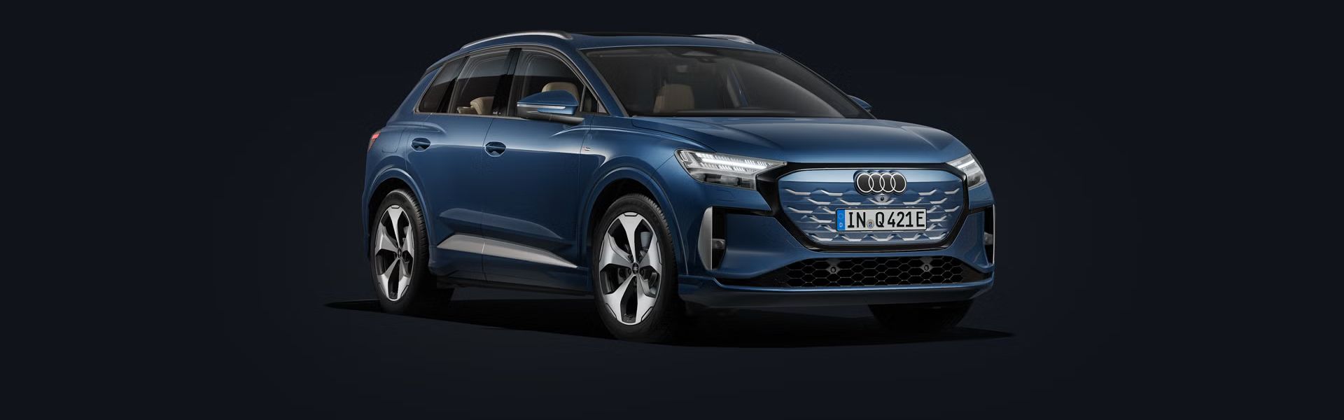 Der Q4 SUV e-tron steht auf dunklem Hintergrund und dreht sich leicht auf die rechte Seite.