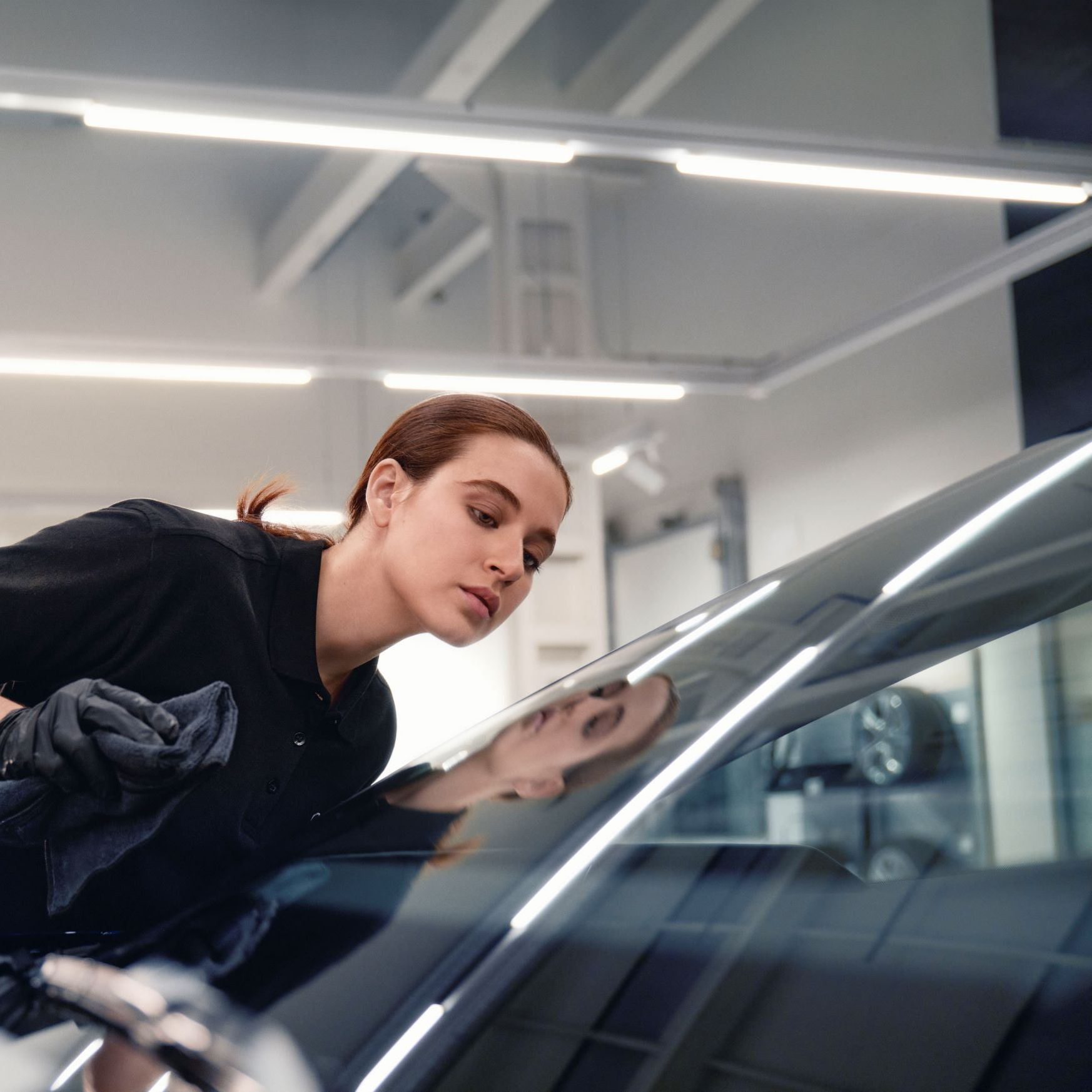 Eine Audi Mechanikerin bei der Reparatur einer Windschutzscheibe