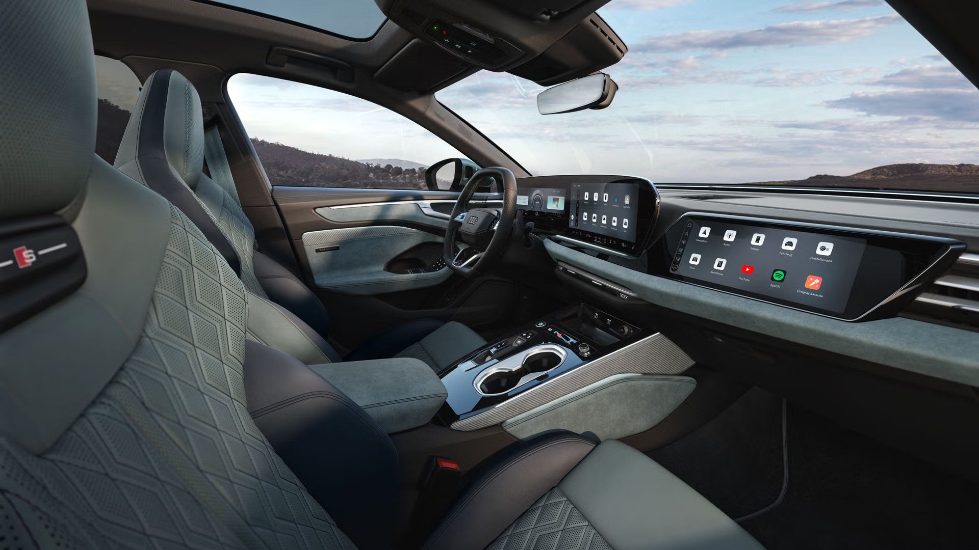 Blick durch das Beifahrerfenster in das Cockpit des A6 Avant e-hybrid. Das Interieur hat mintgraue Bezüge.