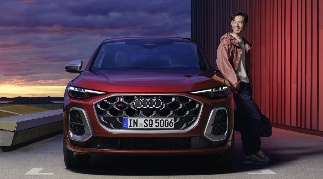 Frontansicht eines roten Audi SQ5 Sportback, an dem ein Mann lehnt