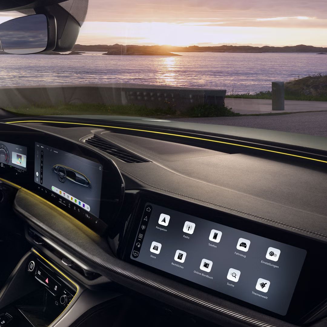 Blick durch das Beifahrerfenster in das Cockpit des SQ5 Sportback. Im Fokus das gelbe Interaktionslicht am unteren Rand der Windschutzscheibe.
