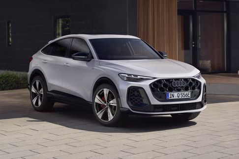 Die weiße Edition One mit mythosschwarzen Akzenten des Q5 Sportback e-hybrid parkt vor einem modernen Haus.