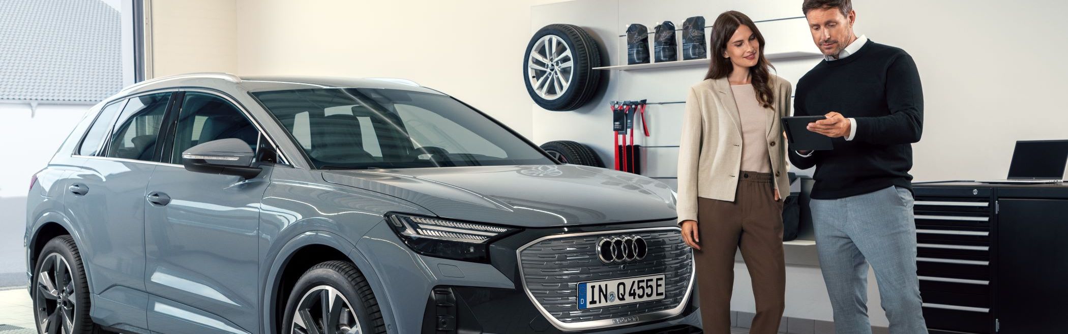 Serviceberater mit Kunde vor dem Q4 e-tron in der Direktannahme