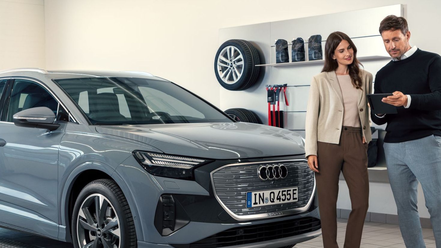 Serviceberater mit Kunde vor dem Q4 e-tron in der Direktannahme