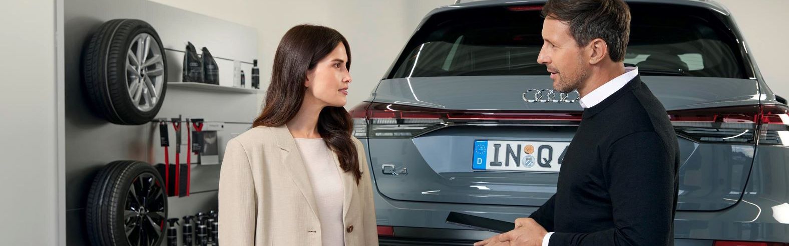 Ein Audi Service Mitarbeiter im Gespräch mit einer Kundin.