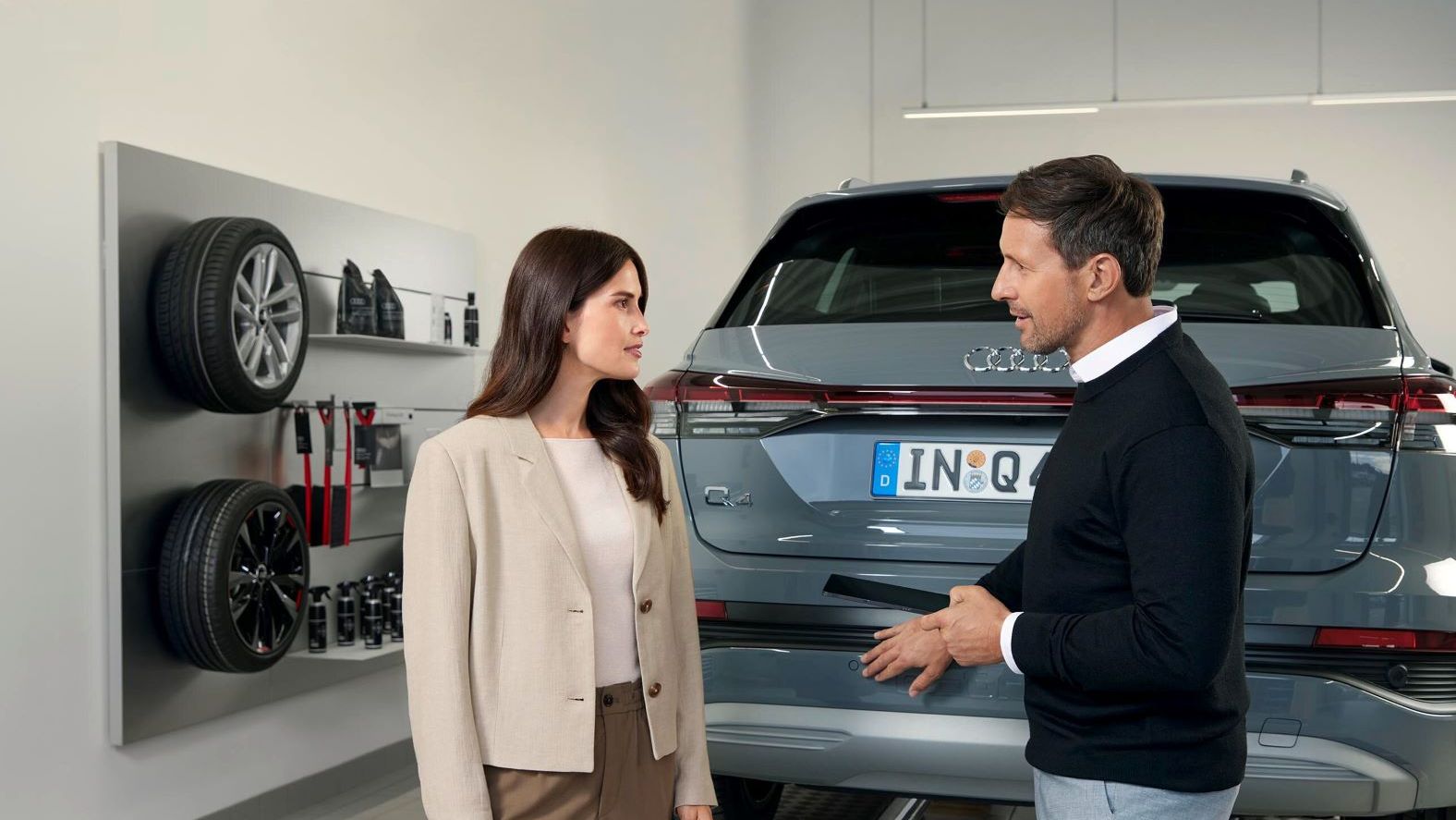 Ein Audi Service Mitarbeiter im Gespräch mit einer Kundin.