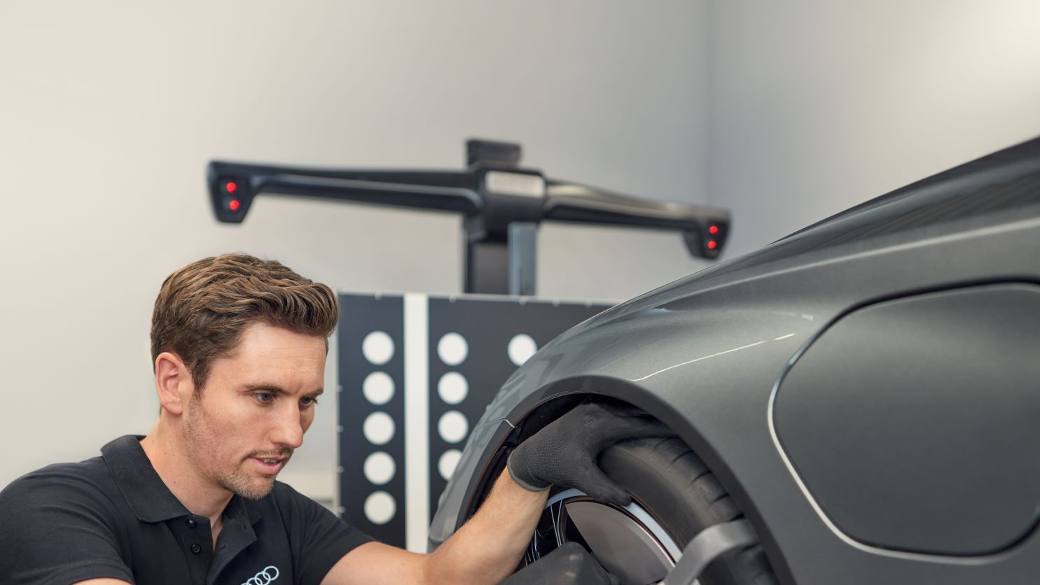 Ein Audi Mechaniker montiert neue Räder an einem Audi