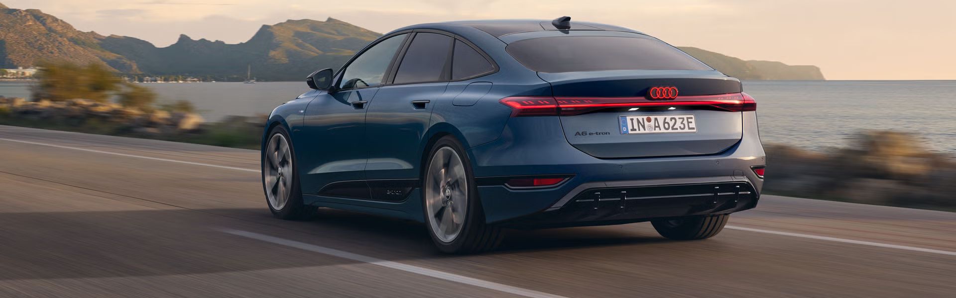 Der A6 Sportback e-tron von schräg oben. Vom Heck und der Front aus unterteilen grüne und blaue Vektoren die Flächen hinter und vor dem Fahrzeug.