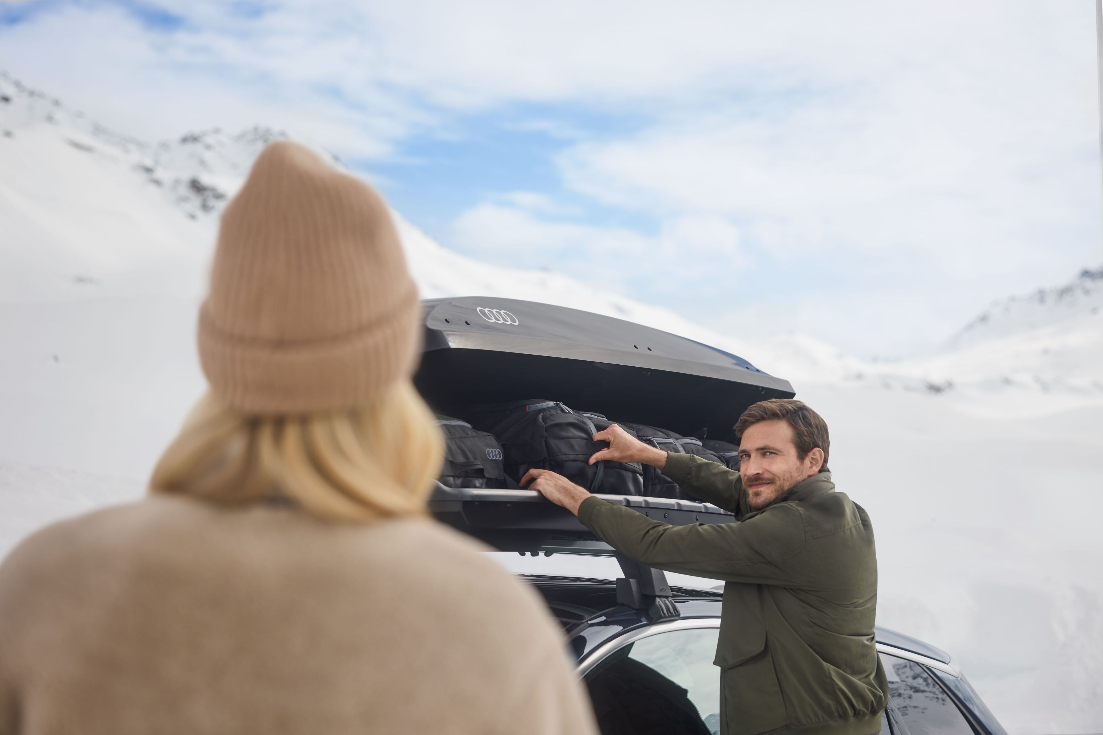 Ein Mann öffnet eine Dachbox auf einem Audi S6
