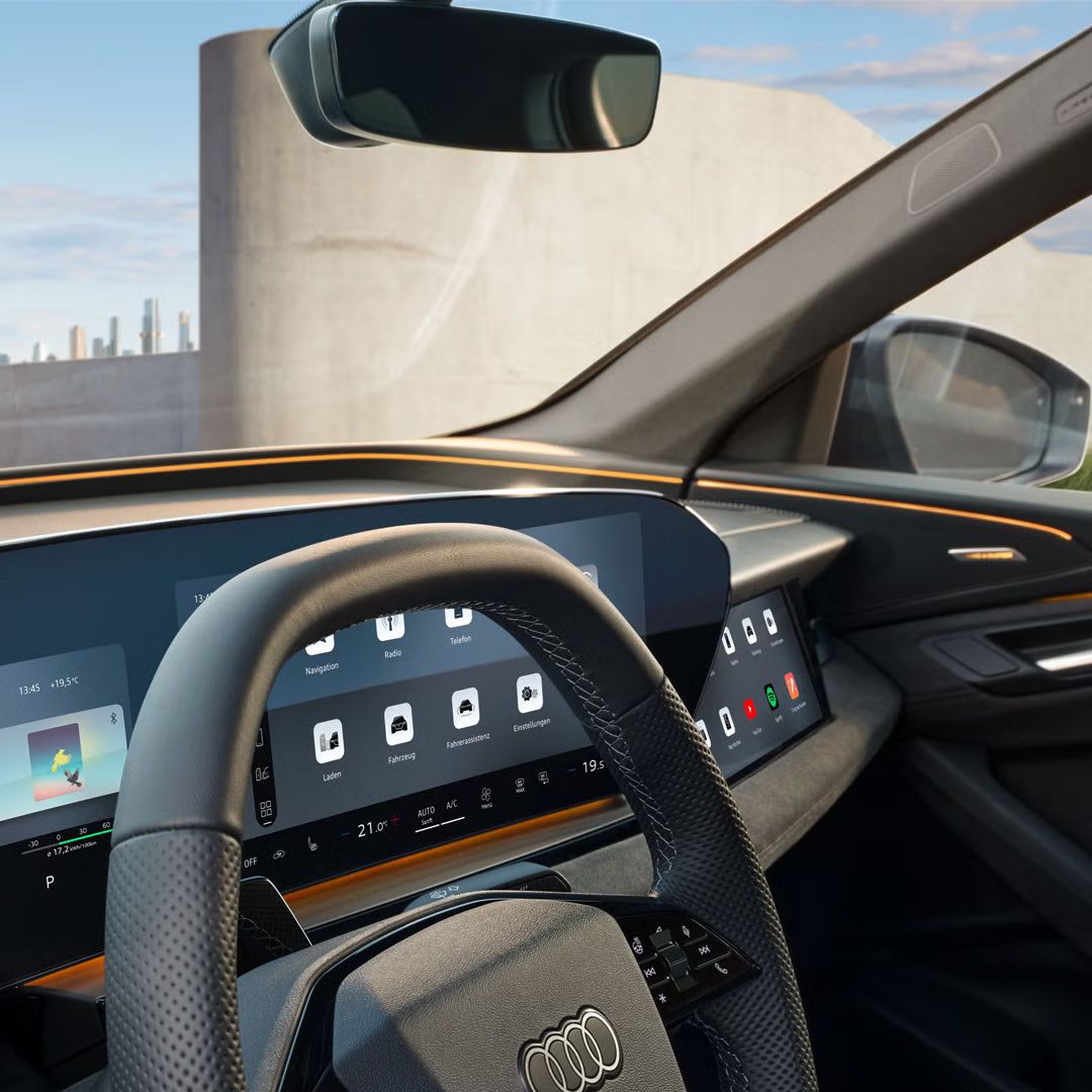 Das Cockpit und Fahrerdisplay aus der Perspektive des Fahrerfensters. Unter der Windschutzscheibe ist das Interaktionslicht in Sonnengelb zu erkennen.