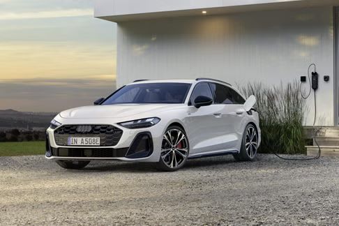 Der A5 Avant e-hybrid ist an eine Ladestation an einem Wohnhaus angeschlossen.