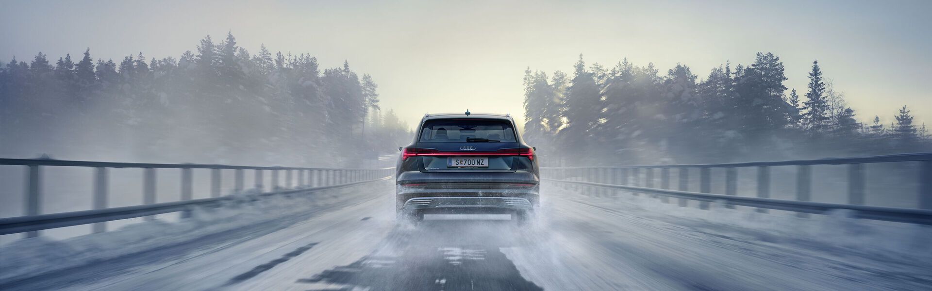 Ein Audi fährt auf einer schneebedeckten Autobrücke