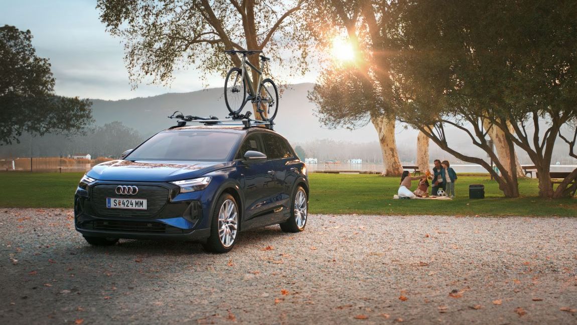 Ein blauer Audi mit Fahrradträger und Fahrrad auf dem Dach.