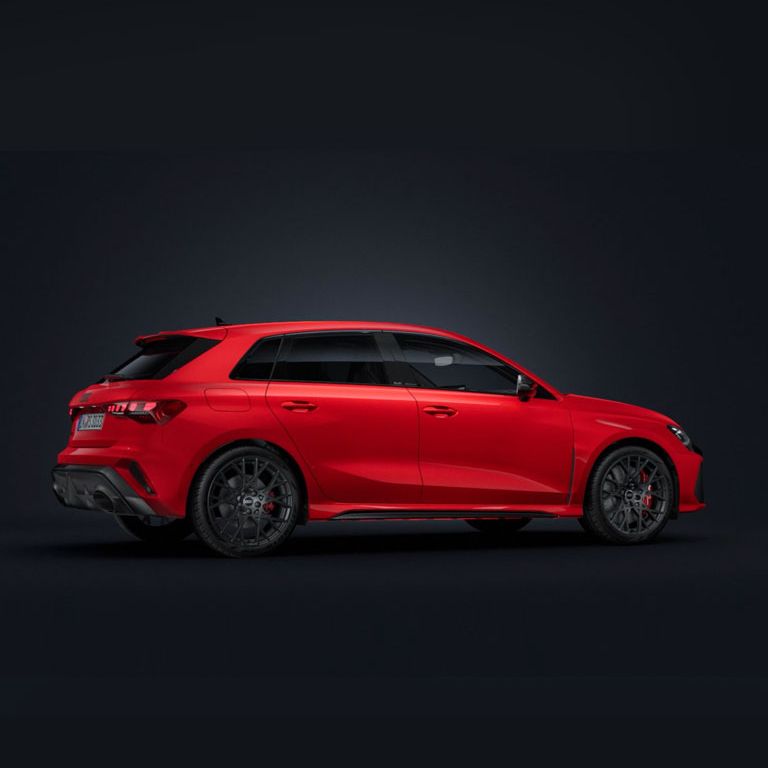 Der Audi RS 3 Sportback steht auf dunklem Hintergrund und dreht sich leicht auf die rechte Seite.