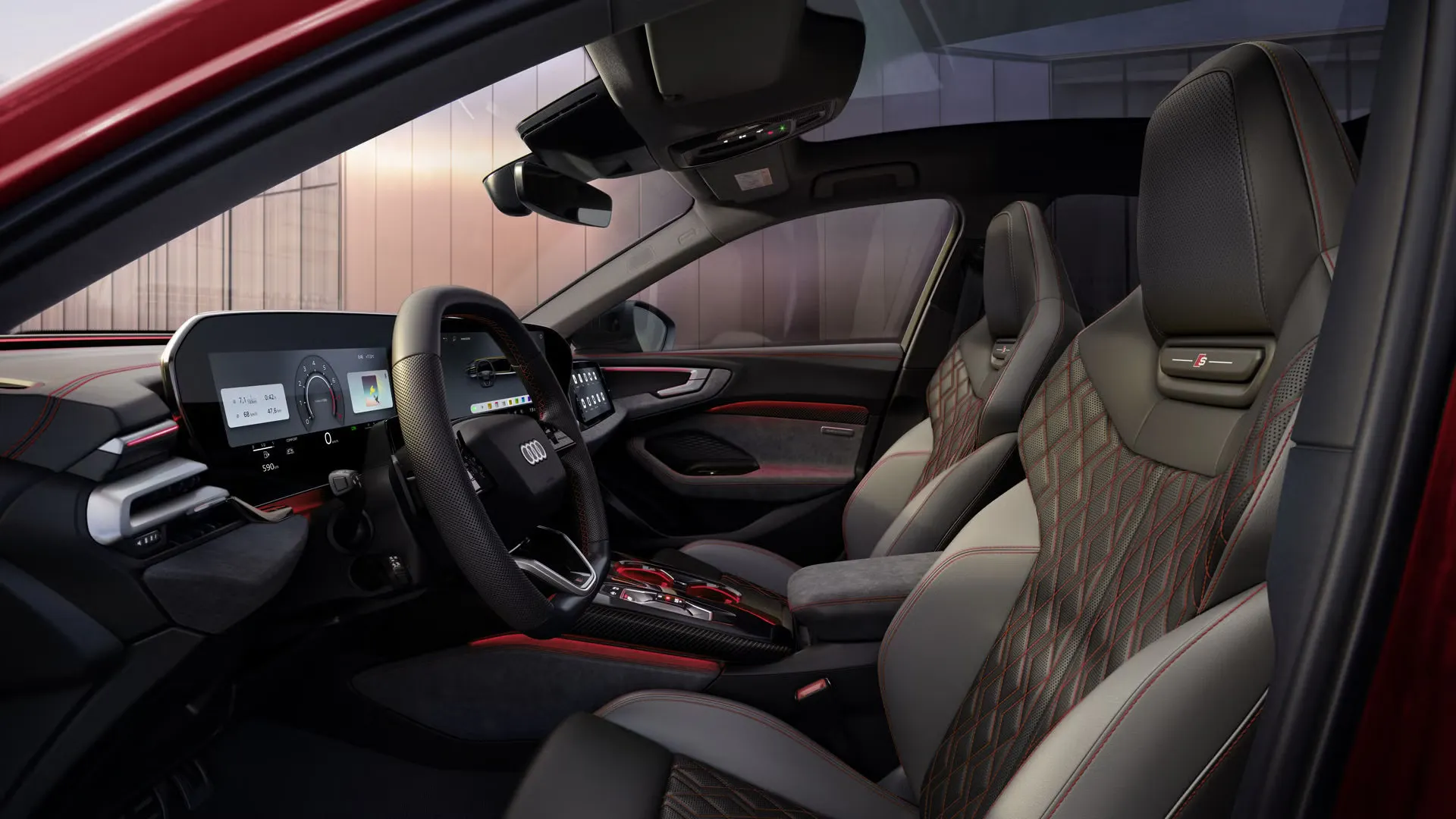 Blick durch die Fahrertür in das Cockpit der A5 Limousine. Die Bezüge im Interieur sind schwarz-jetgrau mit karmesinroten Kontrasten.