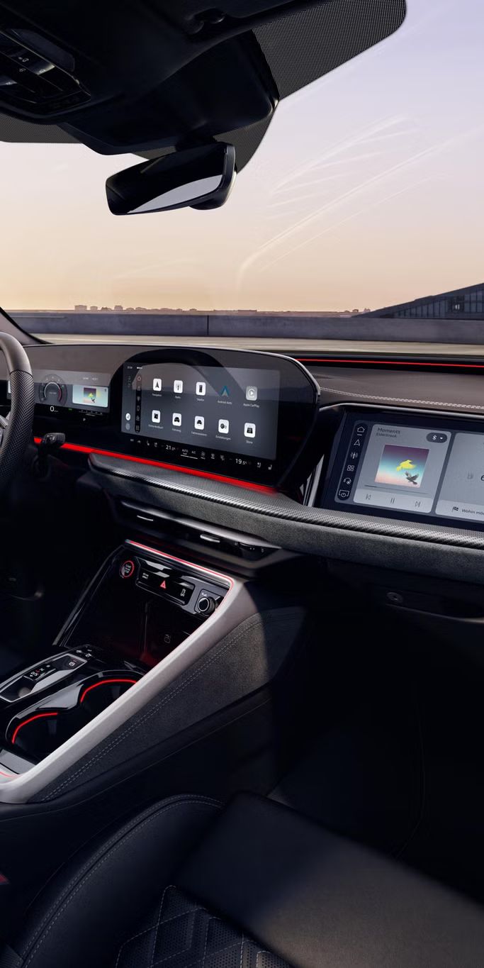 Blick durch das Beifahrerfenster in das Cockpit des SQ5 SUV. Zu sehen sind unter anderem das Panoramadisplay, das MMI Beifahrerdisplay, sowie die rote Ambiente Beleuchtung.