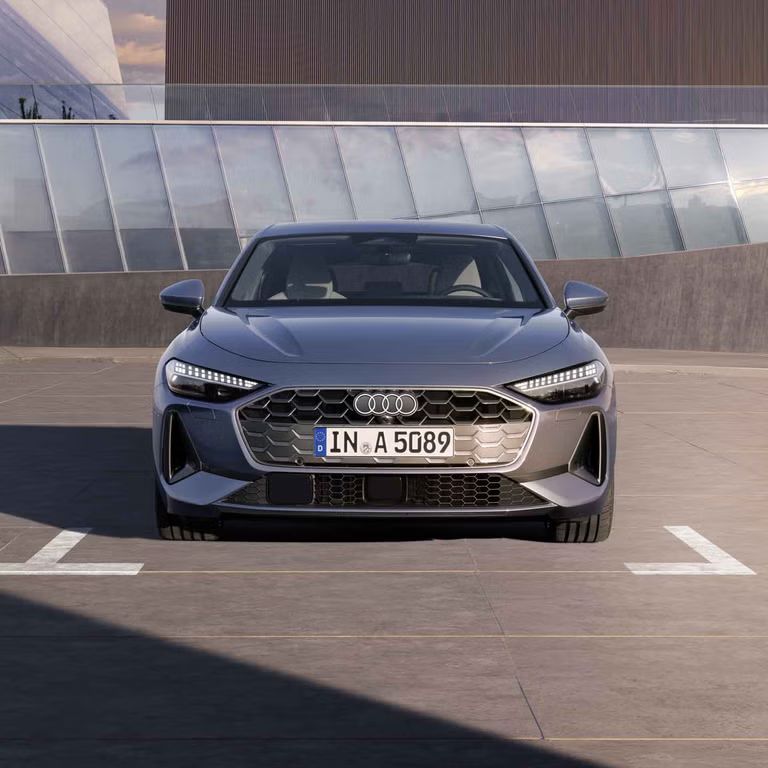 Die A5 Limousine steht im Frontprofil auf einem Parkplatz.